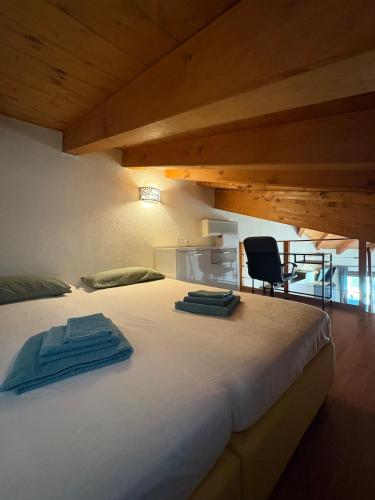 a bedroom with a large white bed and a chair at Garda Resort Apartment in Peschiera del Garda