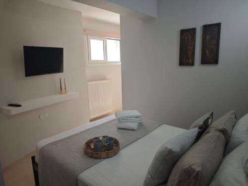 a room with a bed with a television and a basket at Mary's Cozy apartment in Alexandroupoli