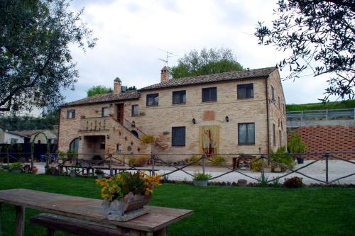 una vieja casa de piedra con una mesa delante en Il Vecchio Pioppo, en Fermo