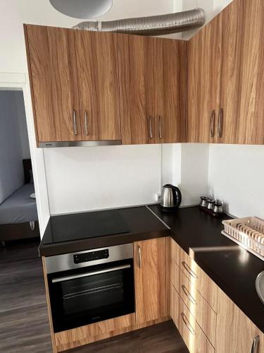 kuchnia z drewnianymi szafkami i kuchenką z piekarnikiem w obiekcie Amore w Ulcinju