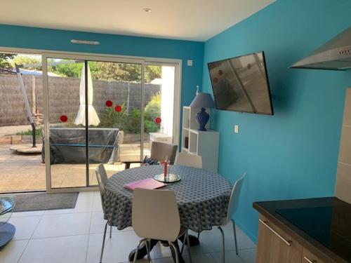 une salle à manger avec une table et des chaises dans une cuisine dans l'établissement La maison du Moulin, à Jard-sur-Mer