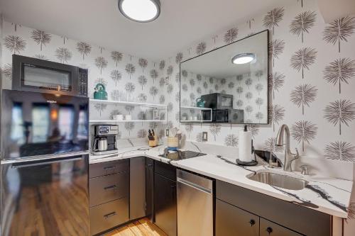 a kitchen with a sink and a mirror at Luxe 220, Unit 5 - Adjacent City View Suites in Wilmington