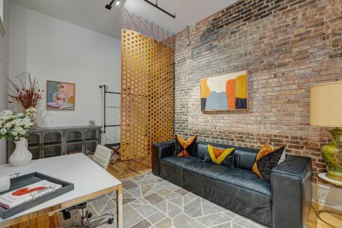 a living room with a couch and a brick wall at Luxe 220, Unit 7 - Entire Penthouse Property - sleeps 20 in Wilmington