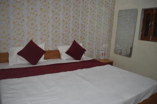 a bedroom with a bed with white sheets and pillows at Hotel the gangotri in Varanasi