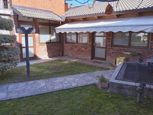 a brick house with an awning and a patio at A casa di 'Nuccia' in Foglizzo