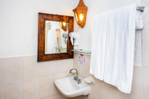 a bathroom with a sink and a mirror at Capital O Hotel Central, Xalapa in Xalapa