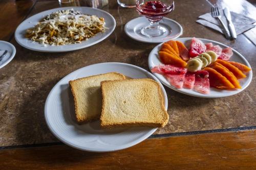 a table with plates of bread and fruits and vegetables at Capital O Hotel Central, Xalapa in Xalapa