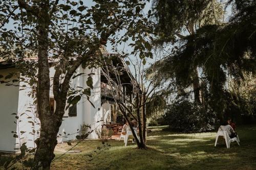 un groupe de personnes assises sur des chaises devant une maison dans l'établissement Gîte Maison Yucca, à Saubion