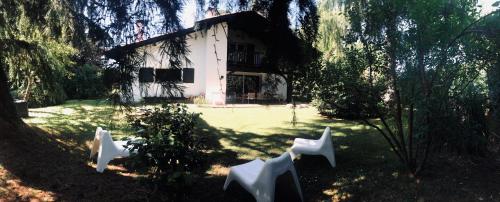 une maison avec des chaises blanches en face d'une cour dans l'établissement Gîte Maison Yucca, à Saubion