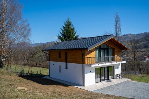 a small house with a black roof on a hill at EDEN HOUSE Viseu de Sus in Vişeu de Sus