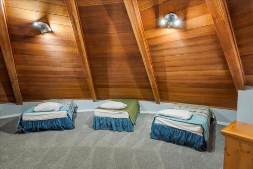 two beds sitting in a room with wood walls at Private Beach, Close To Everything in South Lake Tahoe