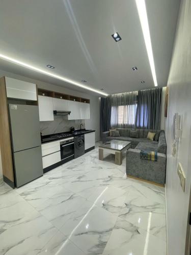 a large kitchen and living room with a couch at Oumaira Residence Azla-Tetouan in Azla