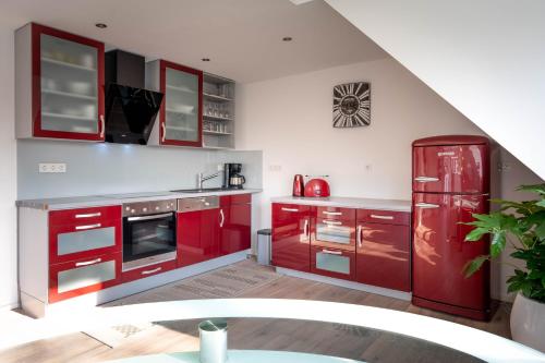 a kitchen with red cabinets and a red refrigerator at Renoviertes Apartment in Troisdorf in Troisdorf