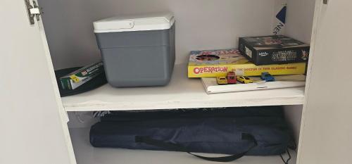 a shelf with a trash can and books on it at Las Julies's Apartment in Arenales