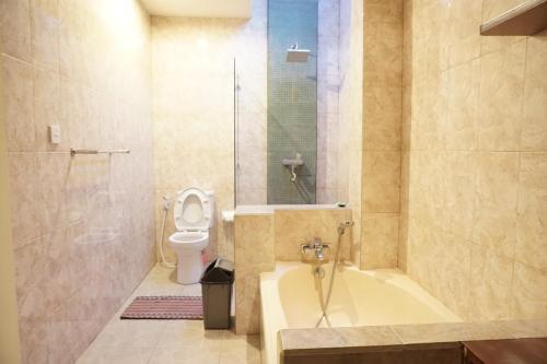 a bathroom with a tub and a toilet and a shower at Praschita Bali in Sanur