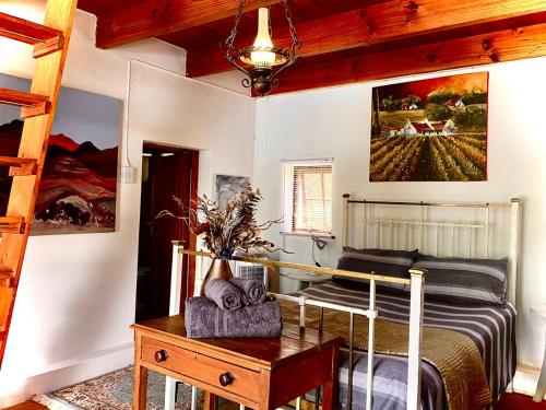 - une chambre avec des lits superposés et une table avec une sidx dans l'établissement Dove Cottage at Rhebokskraal Olive Estate, à McGregor