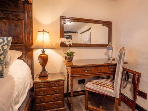 a bedroom with a desk with a mirror and a chair at The Black Boy Inn in Caernarfon