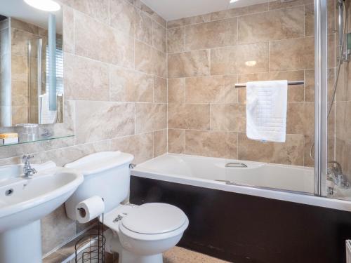 a bathroom with a toilet and a sink and a bath tub at The Black Boy Inn in Caernarfon