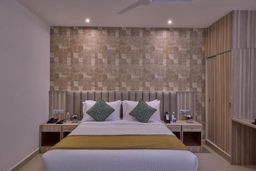 a bedroom with a large bed with pillows at Grand Continent T Nagar in Chennai