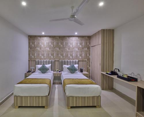 a bedroom with three beds in a room at Grand Continent T Nagar in Chennai