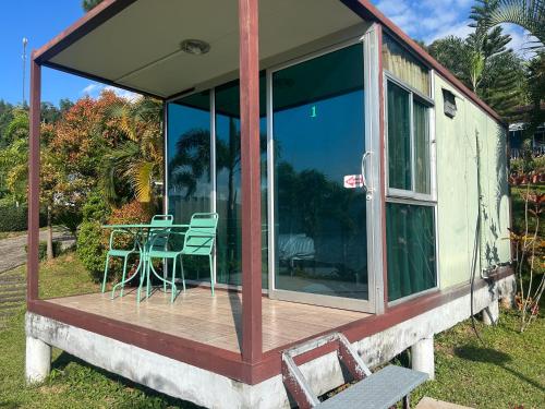 a screened in porch with a table and chairs at FreshBloom View เขาค้อ Green House in Khao Kho