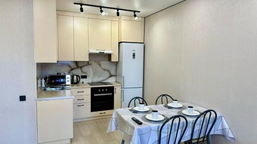 a kitchen with a table and chairs in a kitchen at Syganak Apartments in Astana