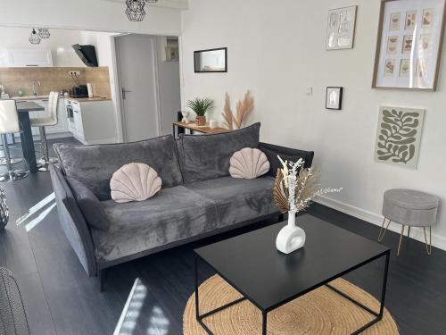 un salon avec un canapé gris et une table dans l'établissement Bel appartement en plein cœur du vieux Troyes., à Troyes