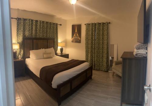 1 dormitorio con cama, sofá y cortinas en classic 4b2b FLL Home with heated pool, en Fort Lauderdale