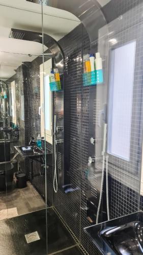 a bathroom with a glass shower and a sink at The Green House in Zaragoza
