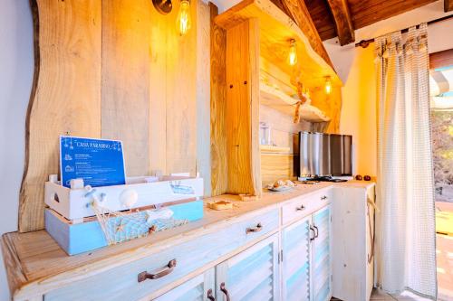 a kitchen with wooden cabinets and a counter top at Casa Paradiso Guest House in Costa Paradiso