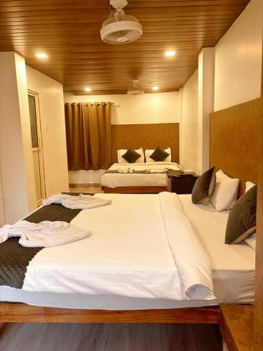 a bedroom with two beds with white sheets at Baga Beach Way in Baga