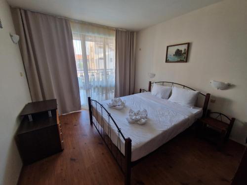 a bedroom with a bed with two dishes on it at MitProt Panorama Bay 2 Apartment 74 in Sveti Vlas