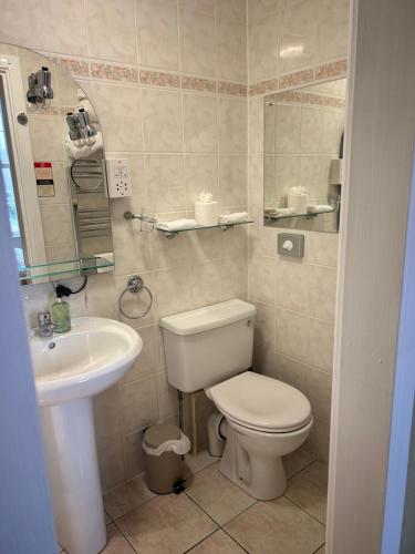 a bathroom with a toilet and a sink at Daviot Guest House in Ayr