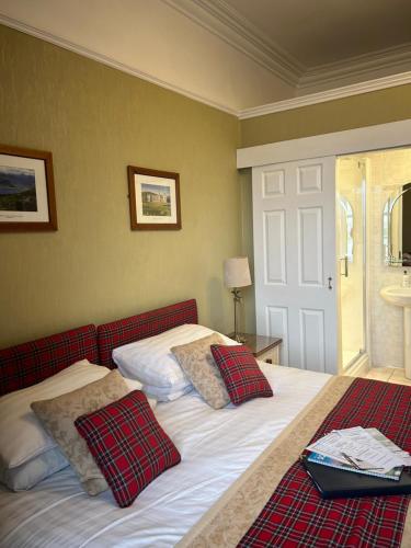 a bedroom with two beds with red and white pillows at Daviot Guest House in Ayr