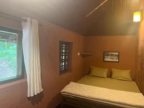 a small bedroom with a bed and a window at Zyamadhari in Mananthavady