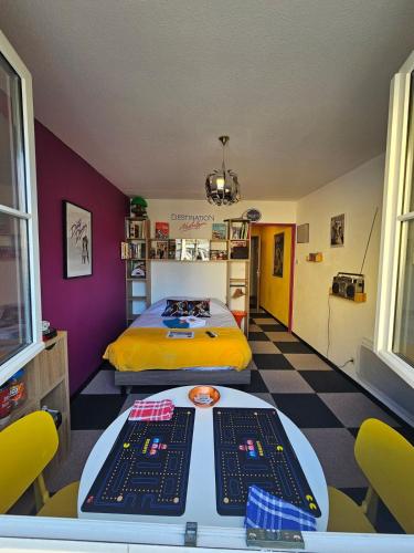 a room with a bed and a table and chairs at Insolite Les années 80 ! in Lunéville