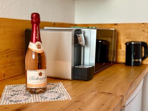 a bottle of wine sitting on a counter next to a microwave at Ferienwohnung am Quedlinburger Stadtbad in Quedlinburg