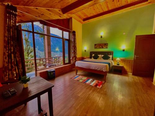 a bedroom with a bed and a large window at 4 Bedroom Luxury Bungalow In Manali With Beautiful Scenic Mountain & Orchard View - #Private Bungalow #Premium Big rooms #Parking #Guest Preferred in Manāli