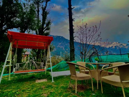 a group of chairs and a table and a tent at 4 Bedroom Luxury Bungalow In Manali With Beautiful Scenic Mountain & Orchard View - #Private Bungalow #Premium Big rooms #Parking #Guest Preferred in Manāli