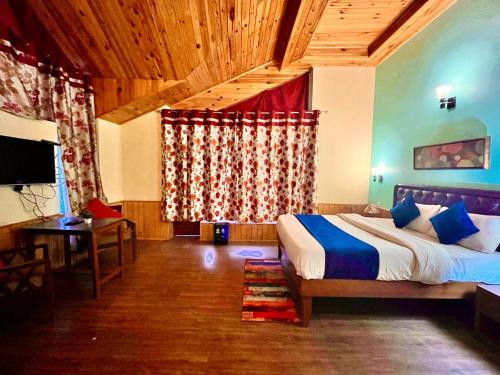 a bedroom with a bed and a table and a television at 4 Bedroom Luxury Bungalow In Manali With Beautiful Scenic Mountain & Orchard View - #Private Bungalow #Premium Big rooms #Parking #Guest Preferred in Manāli