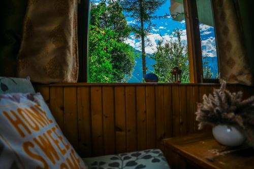 a window in a room with a view of a mountain at 4 Bedroom Luxury Bungalow In Manali With Beautiful Scenic Mountain & Orchard View - #Private Bungalow #Premium Big rooms #Parking #Guest Preferred in Manāli