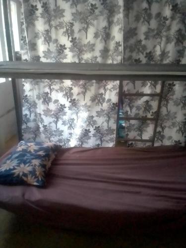 a bedroom with a bed with a floral wallpaper at Himalayan Bed & Breakfast, Triund Trekking and Snowline Trekking Hostel in Dharamshala