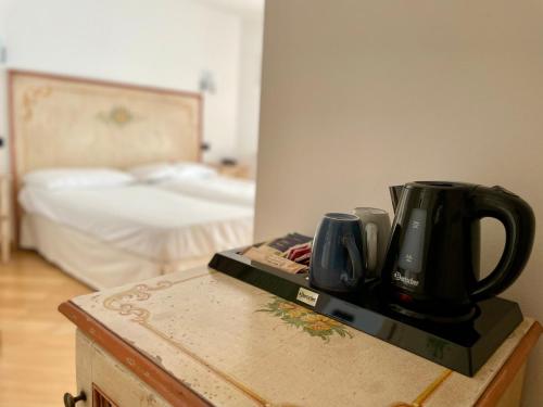 a kitchen counter with two coffee cups and a bed at Relais Fontana Rosa B&B Wellness in Caprino Veronese
