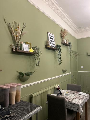 een eetkamer met een tafel en een tafel en stoelen bij Cherwood Guest House in Paignton