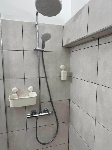 a shower with a shower head and a sink in a bathroom at COMME un POISSON in Sainte-Anne