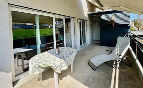 a balcony with a table and a chair on a patio at Grosse Wohnung mit Sauna in Huttwil