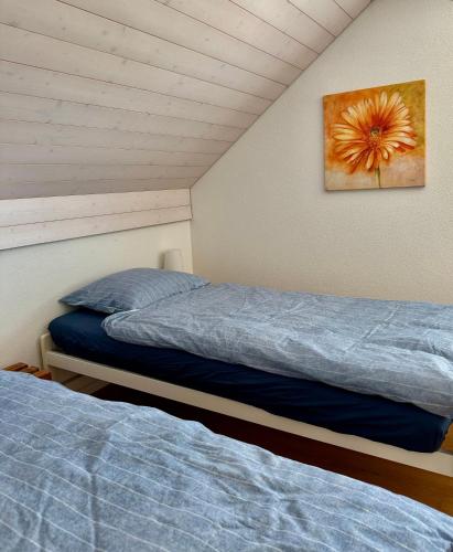 a bedroom with two beds and a painting on the wall at Grosse Wohnung mit Sauna in Huttwil