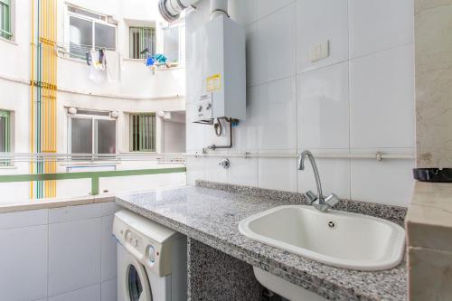 La salle de bains est pourvue d'un lavabo et d'un lave-linge. dans l'établissement Apartment Patacona Beach 9, à Valence