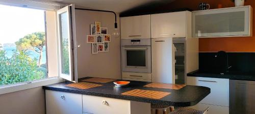 une petite cuisine avec une table et une fenêtre dans l'établissement Didalie locations cigale, à Sainte-Maxime