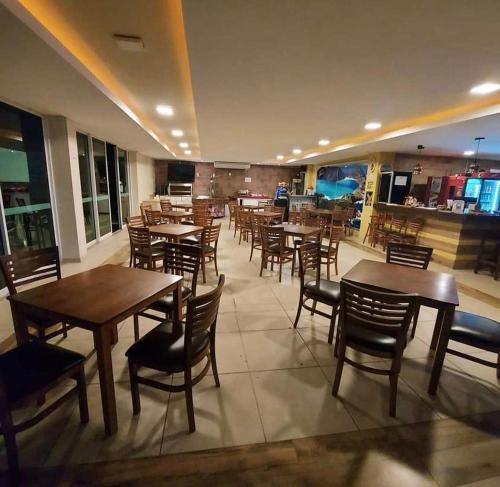 a dining room with wooden tables and chairs at Golden Lake Experiência Inesquecível 6 apto 301 in Arraial do Cabo